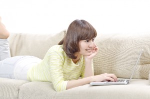 ソファでパソコンを操作する女性